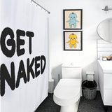 A bathroom featuring a Cotton Cat Funny Letters Black and White Get Naked Shower Curtain-Cottoncat, a toilet, a small trash can, a sink with a round mirror, and two framed artworks of cartoon characters on the wall.