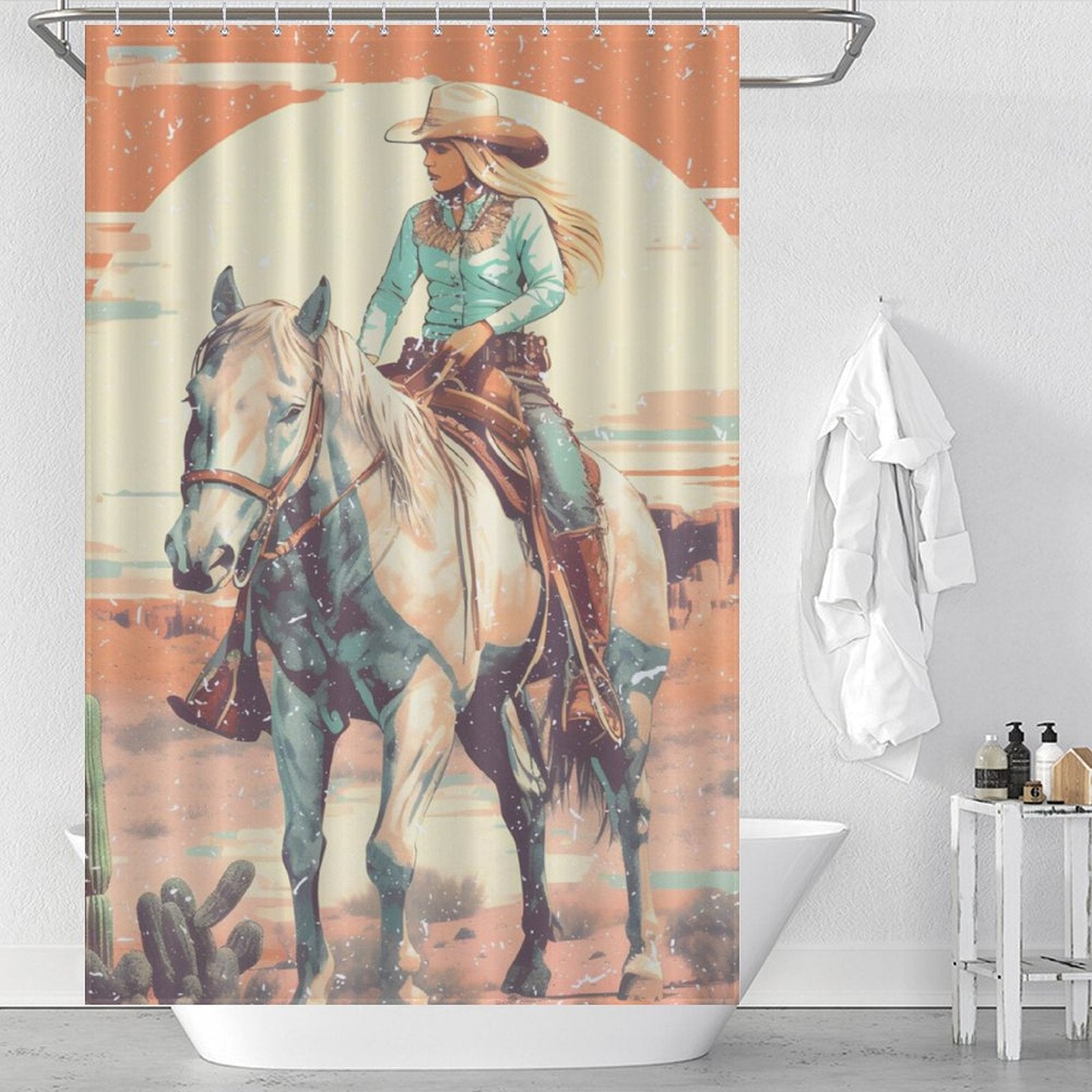 The Rustic Sunrise Western Cowgirl Shower Curtain-Cottoncat by Cotton Cat showcases an illustration of a cowgirl riding a horse in a desert landscape, complete with her wearing traditional attire and hat. The background includes a large setting sun, cacti, and Western charm. It's made of waterproof fabric for added durability.