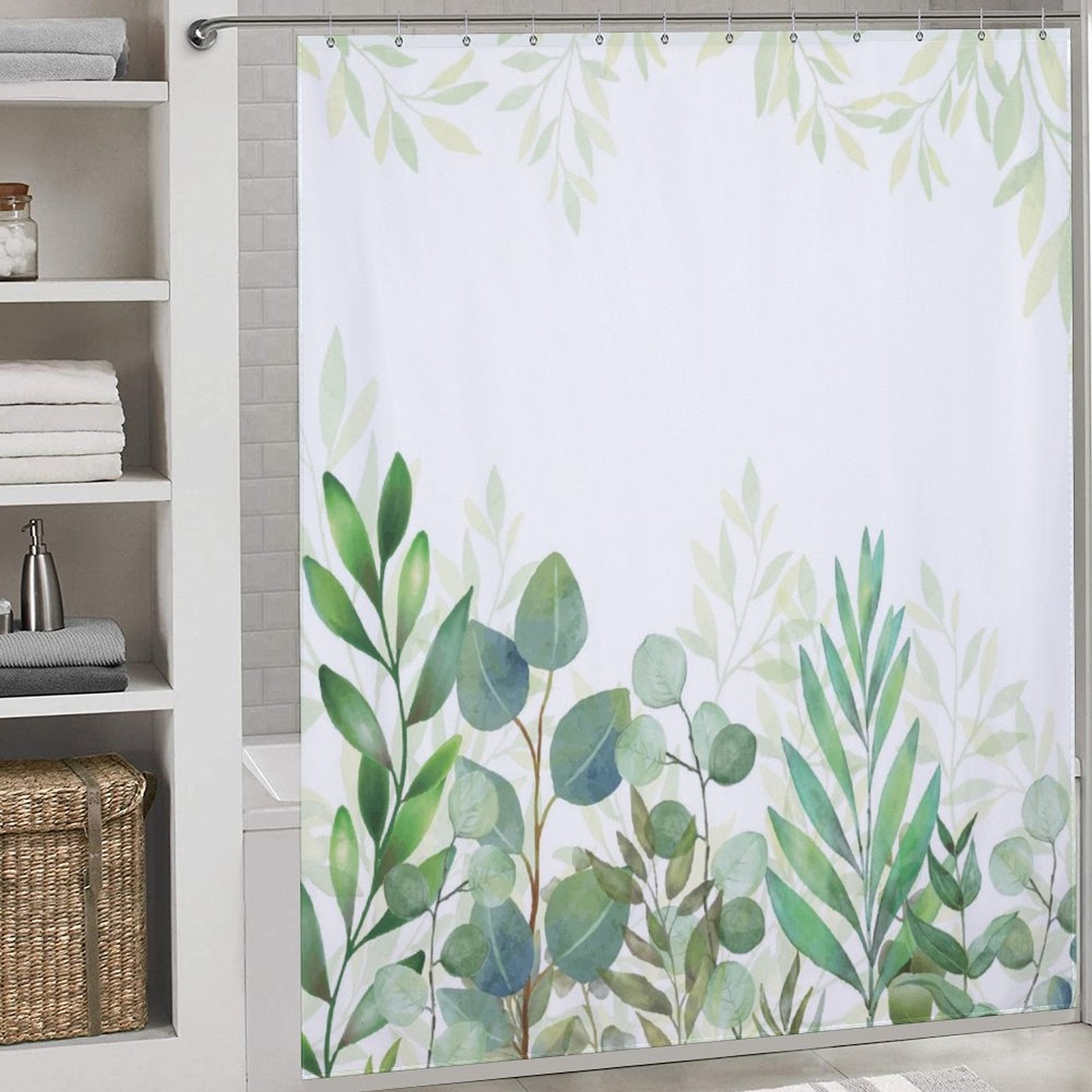 A bathroom with a Cotton Cat Natural Modern Ombre Sage Green White Leaf Shower Curtain-Cottoncat. To the left, there are shelves with folded towels and a wicker basket at the bottom, creating a natural, modern ombre effect.