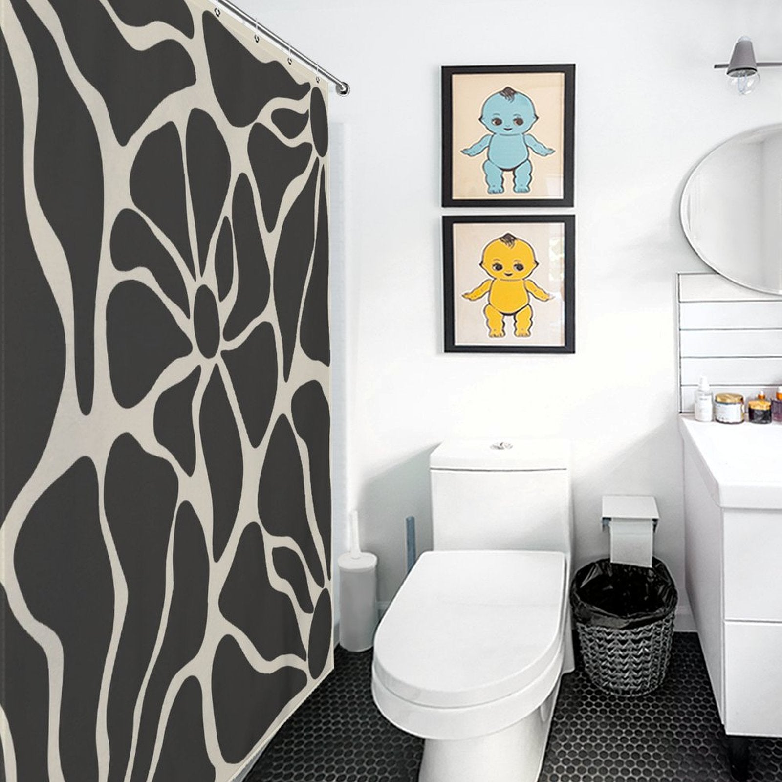 A bathroom with a Vintage Boho Flower Black and Grey Art 70s Black Floral Mid Century Abstract Shower Curtain-Cottoncat, white toilet, sink, and wastebasket. Two framed illustrations of anthropomorphic characters hang on the wall above the toilet.