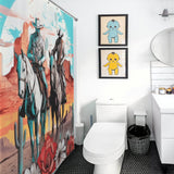A bathroom with a Cowboy Riding Horses Western Shower Curtain-Cottoncat by Cotton Cat, two framed cartoon pictures, a toilet, a wastebasket, and a sink with a mirror above it.
