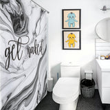 A modern bathroom featuring a "Funny Letters Black and White Marble Get Naked Shower Curtain-Cottoncat" with a white marble pattern, framed baby art on the wall, a white toilet, black trash bin, and a sleek white vanity with a round mirror.