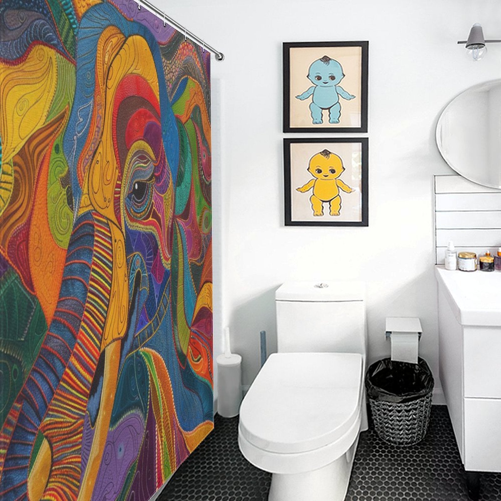 A bathroom featuring a Colorful Abstract Elephant Shower Curtain-Cottoncat by Cotton Cat, two framed baby dinosaur pictures on a white wall, a toilet, a vanity with a round mirror, and a black trash bin on the tiled floor. The vivid colors of the decor bring a playful energy to the space.