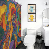 A bathroom featuring a Colorful Abstract Elephant Shower Curtain-Cottoncat by Cotton Cat, two framed baby dinosaur pictures on a white wall, a toilet, a vanity with a round mirror, and a black trash bin on the tiled floor. The vivid colors of the decor bring a playful energy to the space.