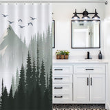 A bathroom featuring a vanity with double sinks, a mirror, and a light fixture above. On the left side hangs the Green Misty Forest Shower Curtain Ombre Sage Green White Nature Tree Mountain Woodland-Cottoncat by Cotton Cat, showcasing an ombre sage green and white design made from mildew-resistant material.