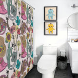 Bathroom with cacti and a Cotton Cat Boots Cactus Bull Skull Sunflower Rustic Vintage Farmhouse Western Shower Curtain-Cottoncat featuring a cowboy hat theme, modern fixtures, black hexagon tile floor, and framed blue and yellow cartoon character art above the toilet.