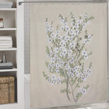 A Retro Green Flower Shower Curtain-Cottoncat by Cotton Cat features a retro floral design with delicate white flowers and green leaves crafted from waterproof fabric. A white shelf with neatly folded towels and a wicker basket is adjacent to the shower.