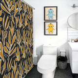 A bathroom featuring a Cotton Cat Abstract Vintage Boho Yellow Leaves Art Mid Century Leaf Shower Curtain, a white toilet, a sink with a mirror, and two framed pictures on the wall above the toilet, depicting stylized blue and yellow characters.
