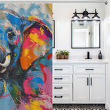 A bathroom with white cabinets and a vanity mirror features a Cute Happy Elephant Shower Curtain-Cottoncat by Cotton Cat with abstract designs on the left side. A black three-light fixture hangs above the mirror, adding character to the charming bathroom decor.