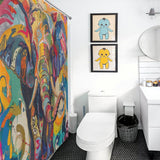 A bathroom with a Multi Colored Happy Elephant Shower Curtain-Cottoncat by Cotton Cat, two framed pictures of cartoon characters above the toilet, and a round mirror above the sink adds playful charm to your bathroom decor.