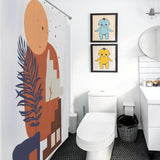 Modern bathroom with an artistic shower curtain featuring Boho Abstract Geometric Modern Art Leaves Sun Arch Minimalist Simple Mid Century by Cotton Cat, a round mirror above the sink, and a pair of framed pictures of cartoon characters on the wall behind the toilet.