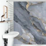 A bathroom features a white sink with a mirror above. The luxurious shower curtain showcases the Gray Gold Stripe Abstract Marble Texture Art Shower Curtain-Cottoncat by Cotton Cat.