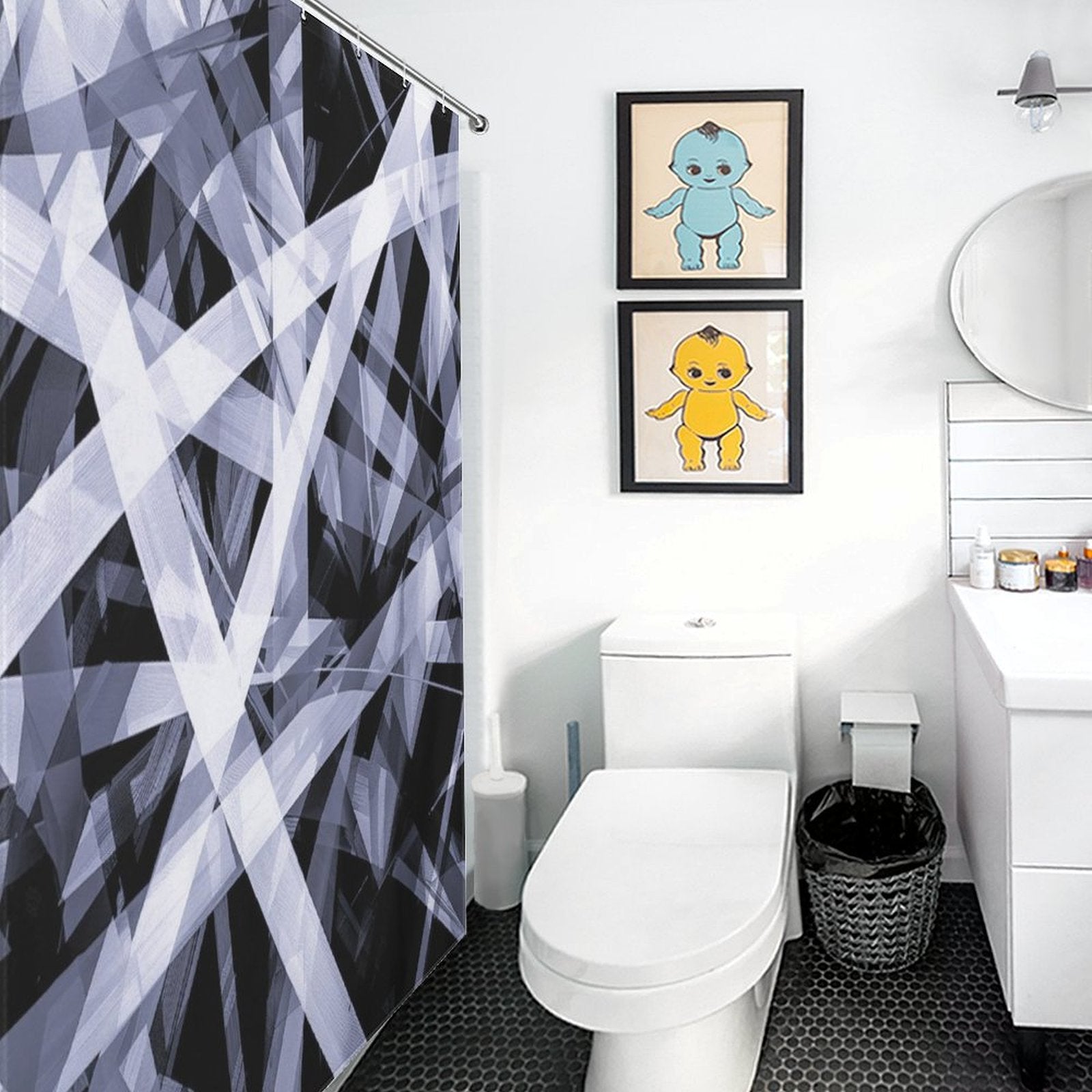 Modern bathroom with a Geometric Black and White Abstract Art Minimalist Line Shower Curtain-Cottoncat by Cotton Cat, toilet, small vanity with round mirror, and two framed geometric black and white abstract art pieces above the toilet. Black hexagon tile floor.