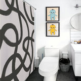 Modern bathroom with black and white decor, featuring a Modern Geometric Art Minimalist Curve Black Line Black and Grey Abstract Shower Curtain-Cottoncat by Cotton Cat, a white toilet, a round mirror, and two framed prints of cartoon babies in blue and yellow.