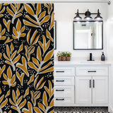 White bathroom with black and yellow botanical-patterned Abstract Vintage Boho Yellow Leaves Art Mid Century Leaf Shower Curtain-Cottoncat by Cotton Cat, white vanity with black handles, wall-mounted mirror, black faucet, and three-light fixture above featuring mid-century leaf design.