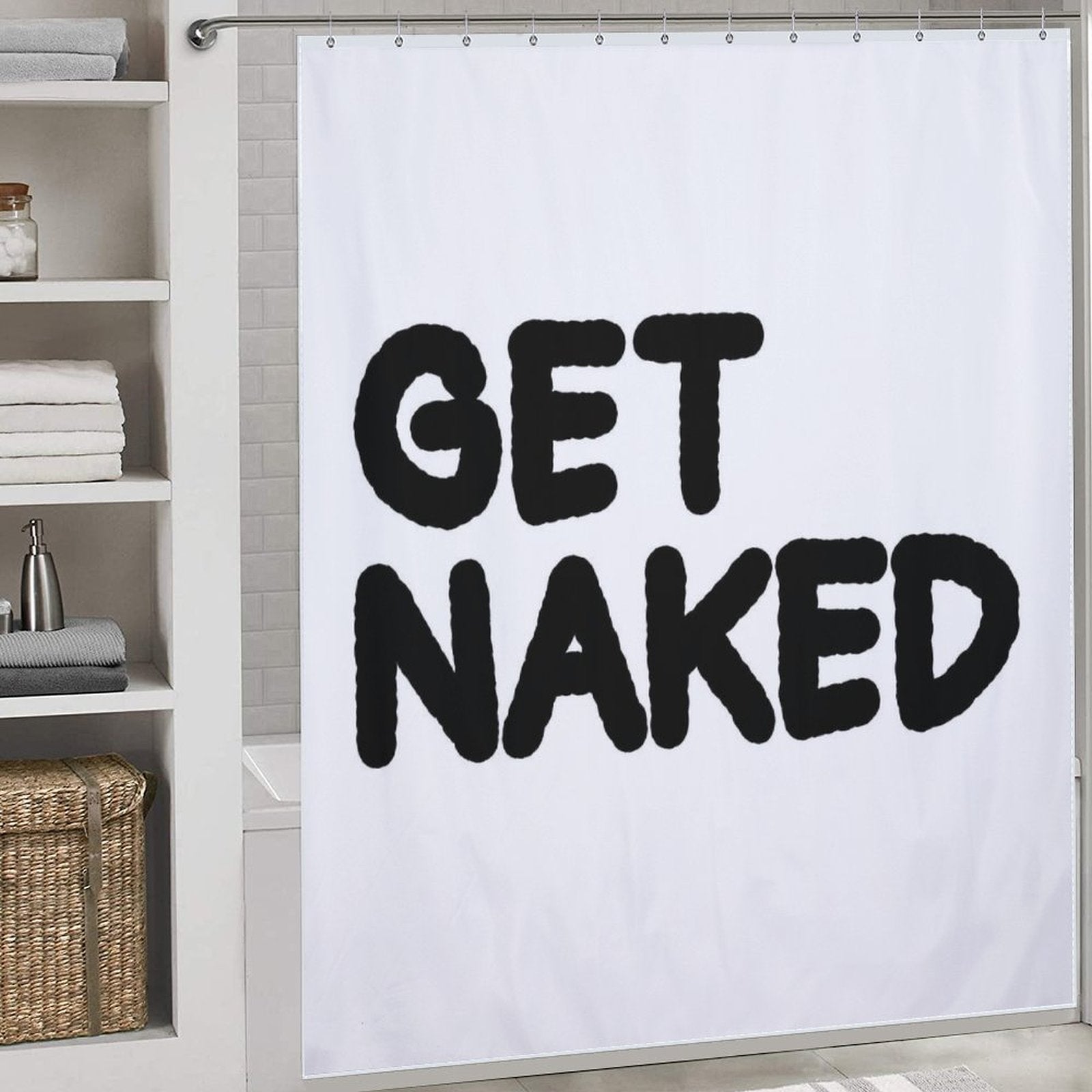 A Funny Letters Black and White Get Naked Shower Curtain-Cottoncat from Cotton Cat hangs in a bathroom, complete with shelves holding towels and a basket nearby.