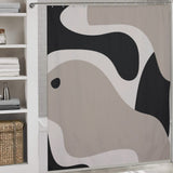 A bathroom with an abstract shower curtain featuring Modern Geometric Art Minimalist Curve Beige Black and Grey Abstract Shower Curtain-Cottoncat by Cotton Cat. There are shelves on the left with folded towels and a woven basket.