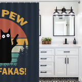 A bathroom with white cabinetry and black fixtures features a Funny Black Crazy Cat with Gun Shower Curtain-Cottoncat displaying a cartoon black cat holding a gun, accompanied by the text "PEW PEW FAKAS!" by Cotton Cat.