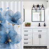 A bathroom with a white vanity, three light fixtures, and an Abstract Modern Art Blue Flower Minimalist Watercolor Blue Floral Shower Curtain-Cottoncat by Cotton Cat. The vanity has drawers and a potted plant on the counter. The floor features patterned tiles.