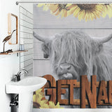 Bathroom with a decorative Highland Cow Sunflowers Get Naked Shower Curtain-Cottoncat featuring a cow with long hair and horns, sticking out its tongue. The curtain has sunflowers and the word "GETNA" in large wooden letters.