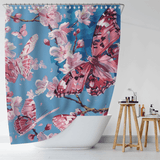 The Cotton Cat "Blue Sky Painting Pink Butterfly Floral Shower Curtain" features a vibrant print of pink butterflies and cherry blossoms on a blue background, simulating a blue sky painting. It hangs elegantly in a modern bathroom with a white bathtub and a wooden stool holding toiletries. Made from water-resistant fabric for enhanced durability.