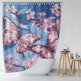 A white bathtub adorned with the Cotton Cat Aesthetic Blue Sky Pink Butterfly Floral Shower Curtain, featuring nature-inspired art with large pink butterflies and cherry blossoms against a serene blue sky background. Beside the tub, a small wooden stool holds toiletries.